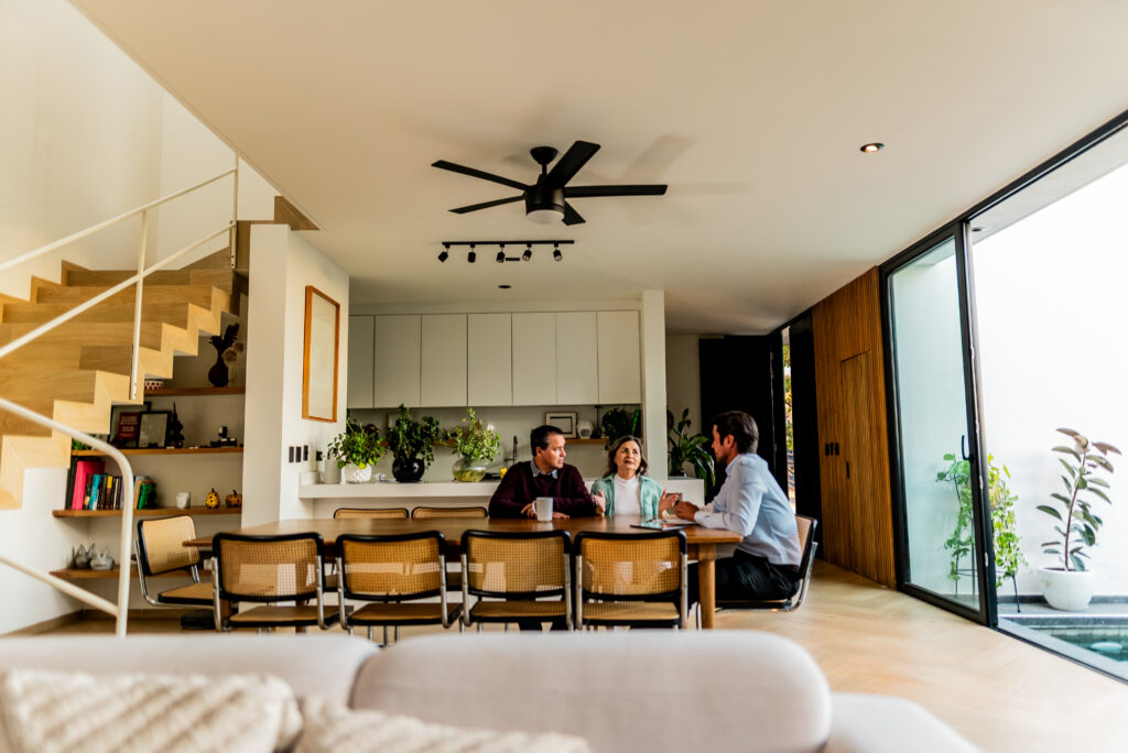 Senior couple talking to real estate agent at house